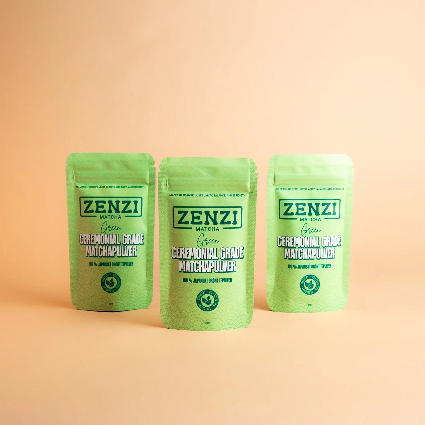 Three green pouches of ceremonial grade matcha powder on a beige background