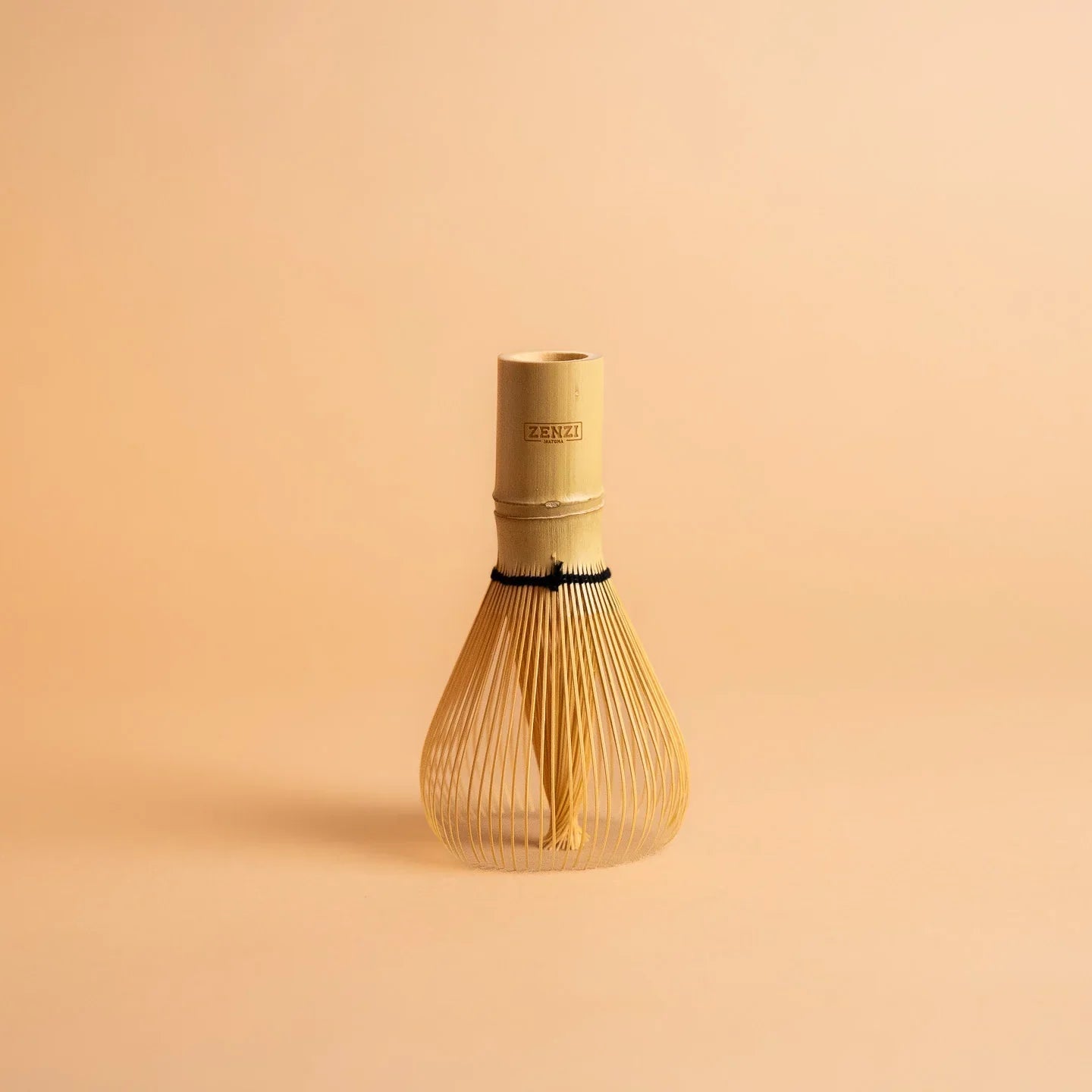 Bamboo matcha whisk on a neutral background, ideal for preparing ceremonial matcha tea.
